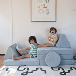Two kids playing on Possum Play Couch in Light Blue in pretend car build