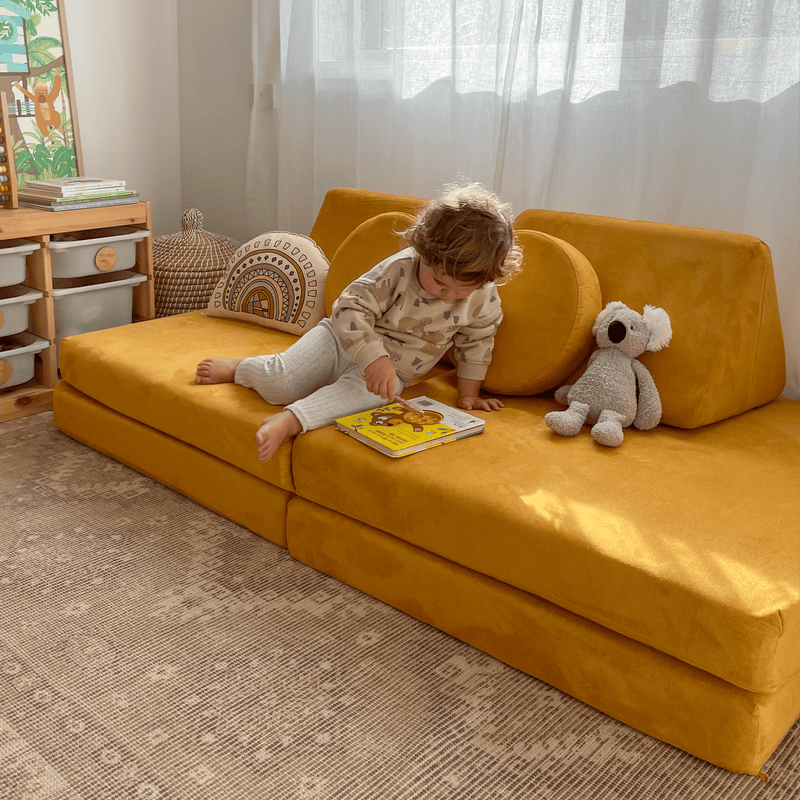 Toddler child reading book on Possum Play Couch in Sunshine Yellow - quiet time play
